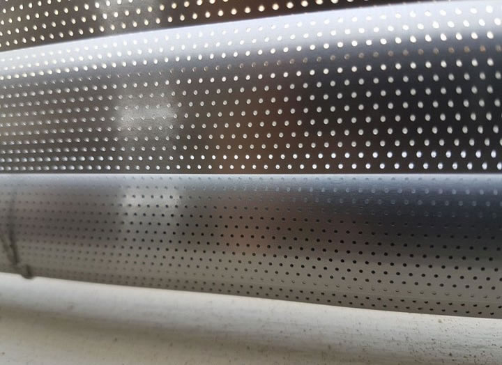 The 25 mm Perforated Silver Venetian Blind is shown in a close-up shot. Notice the holes where the light can filter through. This is an excellent blind for daytime use in an office environment.